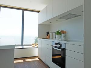 una cucina con armadi bianchi e una grande finestra di Kling am See a Friedrichshafen