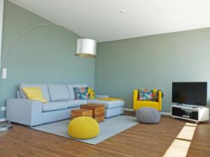 ein Wohnzimmer mit einem Sofa und einem Flachbild-TV in der Unterkunft Kling am See in Friedrichshafen