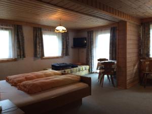 Schlafzimmer mit einem Bett, einem Tisch und Fenstern in der Unterkunft Gästehaus Dorer Gerhard in Prägraten