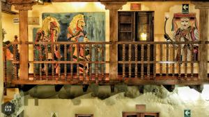 a wooden balcony with paintings on the wall at OkiDoki Cusco Hostal in Cusco