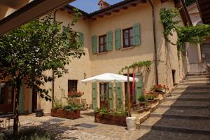 a building with a white umbrella and some plants at Oasi Galbusera Bianca in Rovagnate