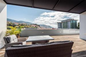 un patio con tavolo e sedie sul balcone. di Casas do Forte do Pico a Funchal