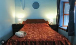 a bedroom with a bed with a red comforter and a window at OkiDoki Cusco Hostal in Cusco