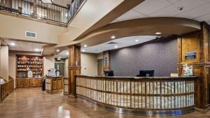 a lobby of a hotel with a bar in it at Best Western Premier Ivy Inn & Suites in Cody