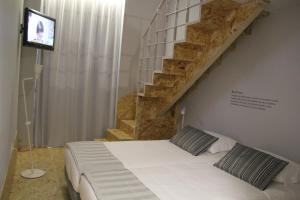 a bedroom with a white bed with a staircase at StayInn City - Póvoa de Varzim in Póvoa de Varzim