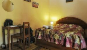 um quarto com uma cama e uma mesa de cabeceira com uma mesa em OkiDoki Cusco Hostal em Cusco