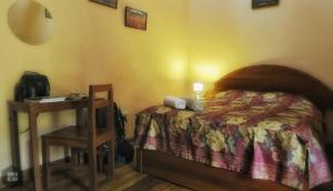 a bedroom with a bed and a night stand with a table at OkiDoki Cusco Hostal in Cusco