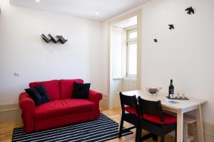 a living room with a red couch and a table at Lively Getaway Apartment in Porto