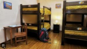 a room with three bunk beds and a backpack on the floor at OkiDoki Cusco Hostal in Cusco