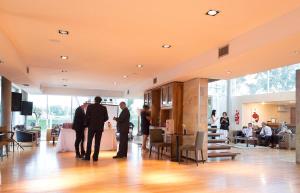 a group of three men standing in a lobby at Herradura Hotel Suites in Neuquén
