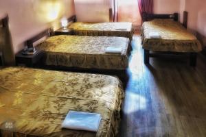 a room with three beds in a room at OkiDoki Cusco Hostal in Cusco