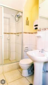 a bathroom with a toilet and a shower and a sink at OkiDoki Cusco Hostal in Cusco