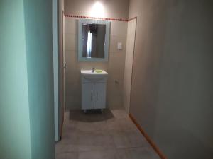 a small bathroom with a sink and a mirror at cabañas La Victoria in La Falda +25 photos