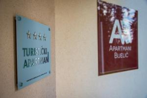 a sign on a wall next to a american apartmentarian block at Apartmani Bijelic in Žabljak