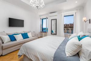 Un dormitorio con una cama grande y un sofá. en Luxury apartment Karolina Riva 101m2, en Rijeka