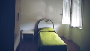 a small bed in a room with a table at Cà della Roggia in Rovereto