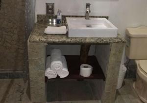 baño con lavabo y rollos de papel higiénico en Eco Hotel Tahawi, en Ajijic