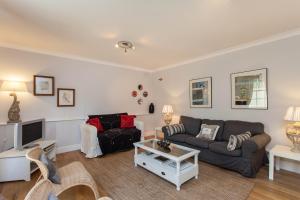 a living room with a couch and a tv at Charming Paddington in London