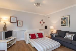 a living room with a couch and a tv at Charming Paddington in London