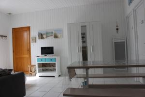 a living room with a table and a television at GITE AVEC SPA ENTRE FORET ET PLAGE - Ambiance Bord de Mer in Saint-Hilaire-de-Riez