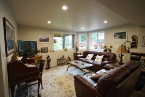 uma sala de estar com sofás de couro e uma televisão em Deer Ridge B&B em Golden