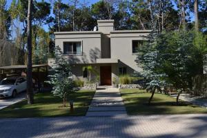 una casa con un'auto parcheggiata davanti di Casa en Barrio Cerrado en Rincón del Indio cerca del mar a Punta del Este