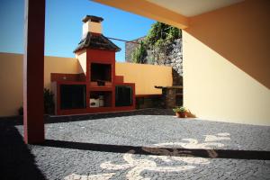 a courtyard with a building with a light house at Raposeira Chloe T2 in Fajã da Ovelha