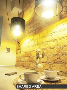 una mesa con dos tazas de café y una lámpara en Emi apartment, en Vilna