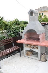 um forno de pizza numa mesa ao lado de um banco em Lavanda em Podstrana
