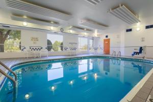 a swimming pool with blue water in a building at AmericInn by Wyndham Appleton Airport in Appleton