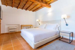 
a bedroom with a white bed and white walls at Agroturismo Can Toni Xumeu - Adults Only in Cala Llonga
