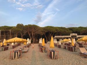 einen Strand mit Sonnenschirmen und Stühlen und eine Person, die auf dem Sand läuft in der Unterkunft Hotel Villa Aljor in Golem