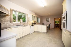 a large kitchen with white cabinets and a table at Luxury Manor, Private, Double Garage, Hot tub, Wifi in Ballinderry Upper