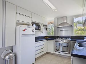 a kitchen with white cabinets and a white refrigerator at FRD02 Casa charmosa no Condomínio Porto Frade in Angra dos Reis