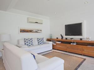 a living room with a white couch and a flat screen tv at FRD02 Casa charmosa no Condomínio Porto Frade in Angra dos Reis