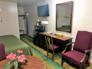 a hotel room with a desk and a bed and a mirror at Atlantic Motel in East Wareham