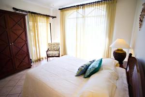 a bedroom with a bed with pillows on it at Stay in Tamarindo Condominiums in Tamarindo