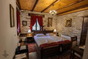 1 dormitorio con cama y pared de piedra en Hotel Kastro, en Gjirokastra