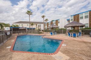 a swimming pool at a resort with chairs and umbrellas at La Playa Condominium 209 in South Padre Island