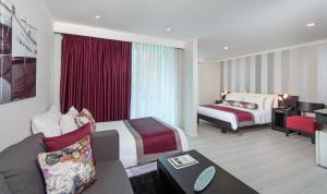 Habitación de hotel con 2 camas y sofá en The Morgana Poblado Suites Hotel, en Medellín