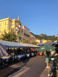 a woman walking down a street with an umbrella at Moulin -Old Town in Nice