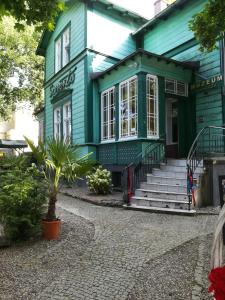 a green house with a palm tree in front of it at Willa Sorrento in Szczecin