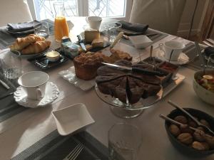 uma mesa com um monte de pão e bolos sobre ele em Chambres d'Hotes au Pays de Valencay en Berry em Valençay