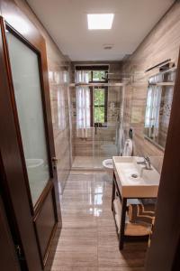 een badkamer met een wastafel, een toilet en een douche bij Hotel Kastro in Gjirokastër