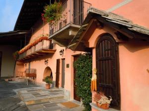 un edificio rosa con porta e balcone di B&B Il Mulino a Sanfront