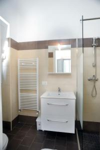 La salle de bains est pourvue d'un lavabo blanc et d'une douche. dans l'établissement Elis...land..., à Torre Canne