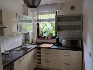 a kitchen with a sink and a microwave at 2-Zimmer-Apartment Ratingen Ost in Ratingen