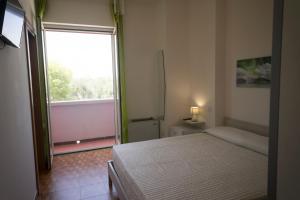 a bedroom with a bed and a large window at Paradise beb in Giovinazzo