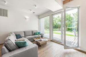 ein Wohnzimmer mit Sofa und großer Glasschiebetür in der Unterkunft Housea Domy Wakacyjne in Jantar