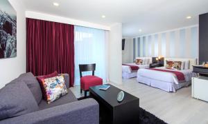Habitación de hotel con sofá y 2 camas en The Morgana Poblado Suites Hotel, en Medellín